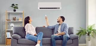 Pareja usando aire acondicionado en el living