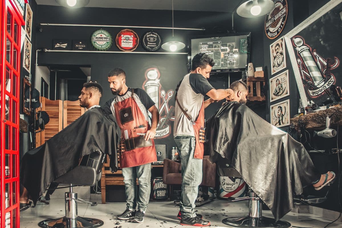 Barbero realizando un corte de pelo en una barbería en Uruguay